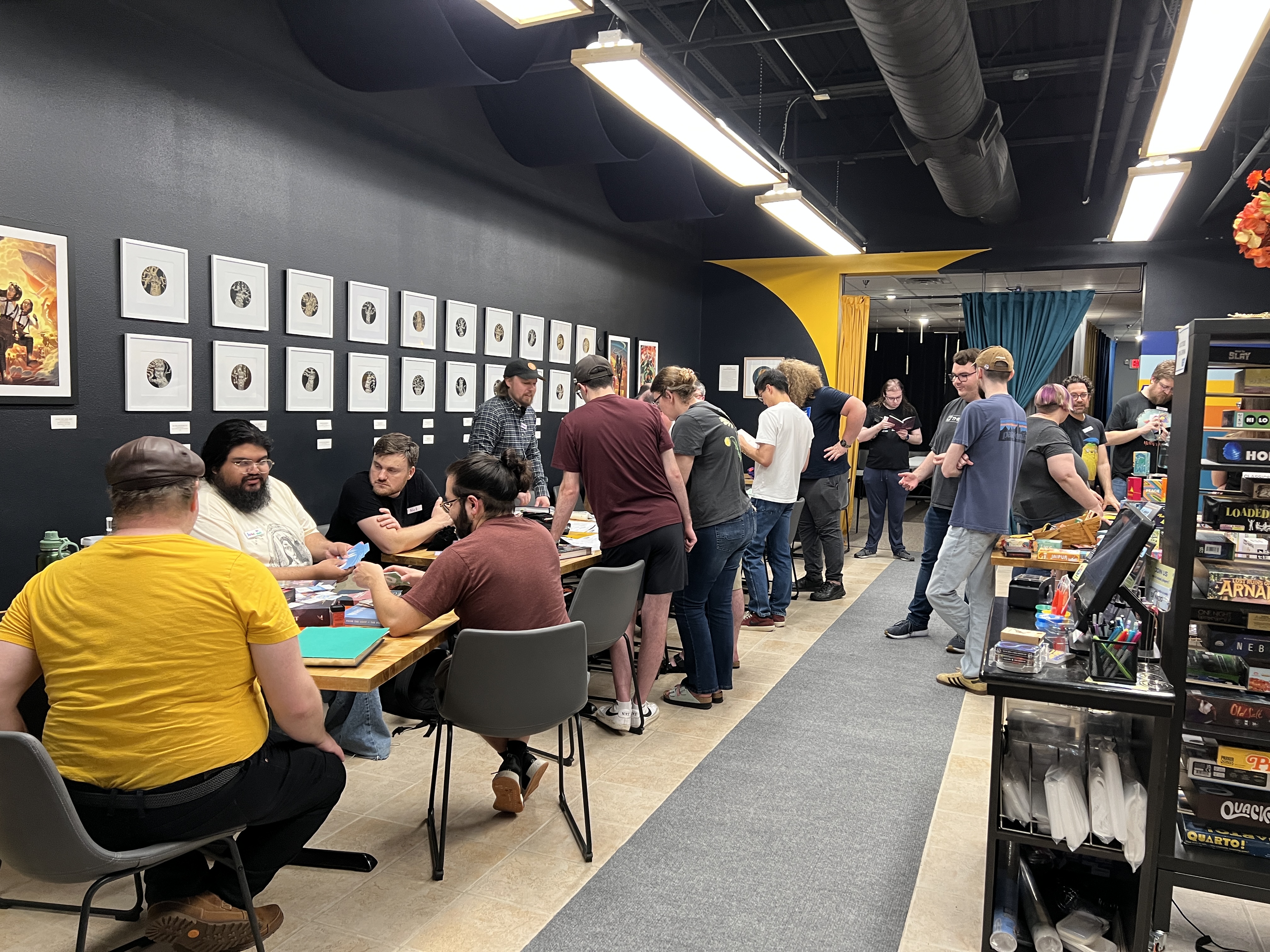 People sitting and standing in Diversions' game hall.